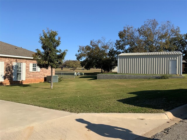 view of yard with central AC and an outdoor structure