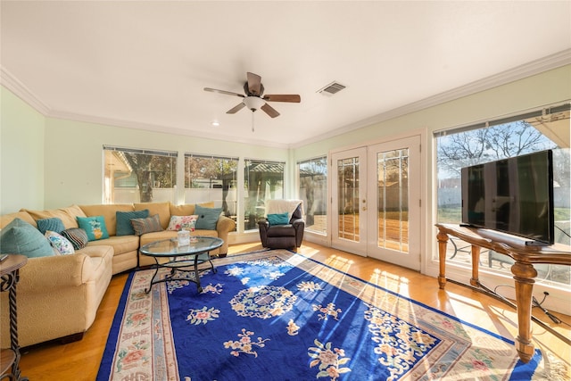 sunroom / solarium with ceiling fan and french doors