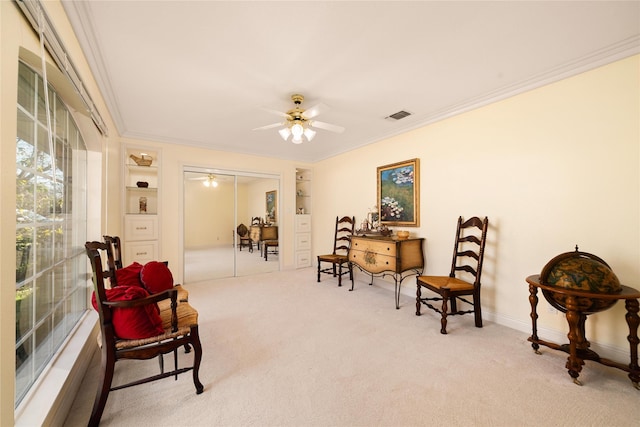 living area featuring carpet flooring, built in features, ceiling fan, and crown molding