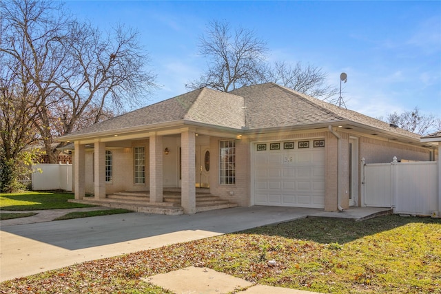 view of front of house featuring covered porch, a front yard, and a garage