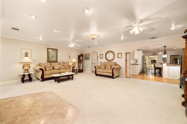 carpeted living room with ceiling fan and ornamental molding