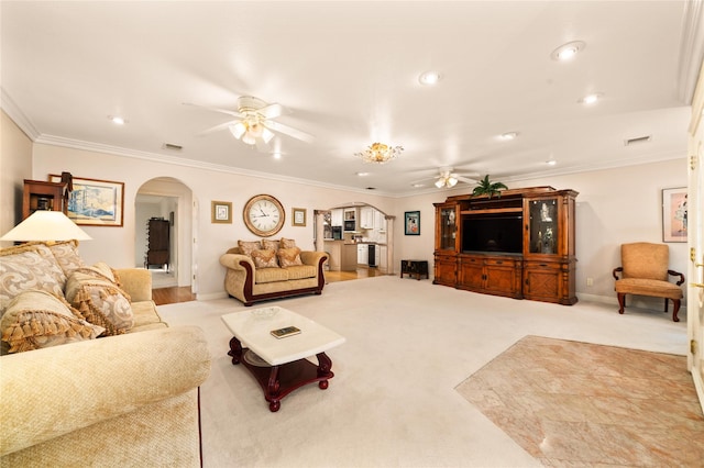 carpeted living room with ceiling fan and crown molding