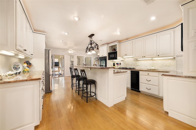 kitchen featuring white cabinetry, ceiling fan, light hardwood / wood-style flooring, pendant lighting, and a kitchen island