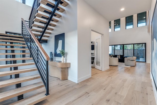 staircase featuring hardwood / wood-style floors and a high ceiling