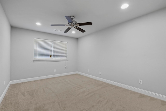 spare room featuring ceiling fan and light carpet