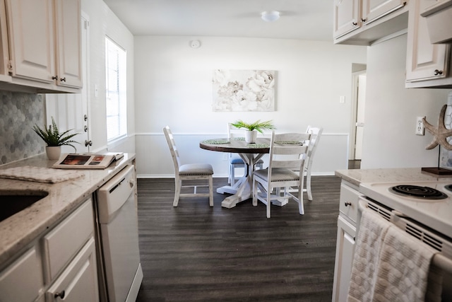 kitchen featuring white appliances, dark wood-type flooring, white cabinets, light stone countertops, and tasteful backsplash