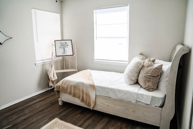 bedroom featuring dark hardwood / wood-style flooring and multiple windows