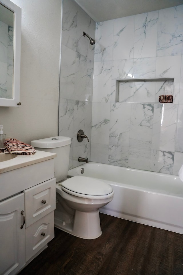 full bathroom featuring hardwood / wood-style flooring, vanity, toilet, and tiled shower / bath