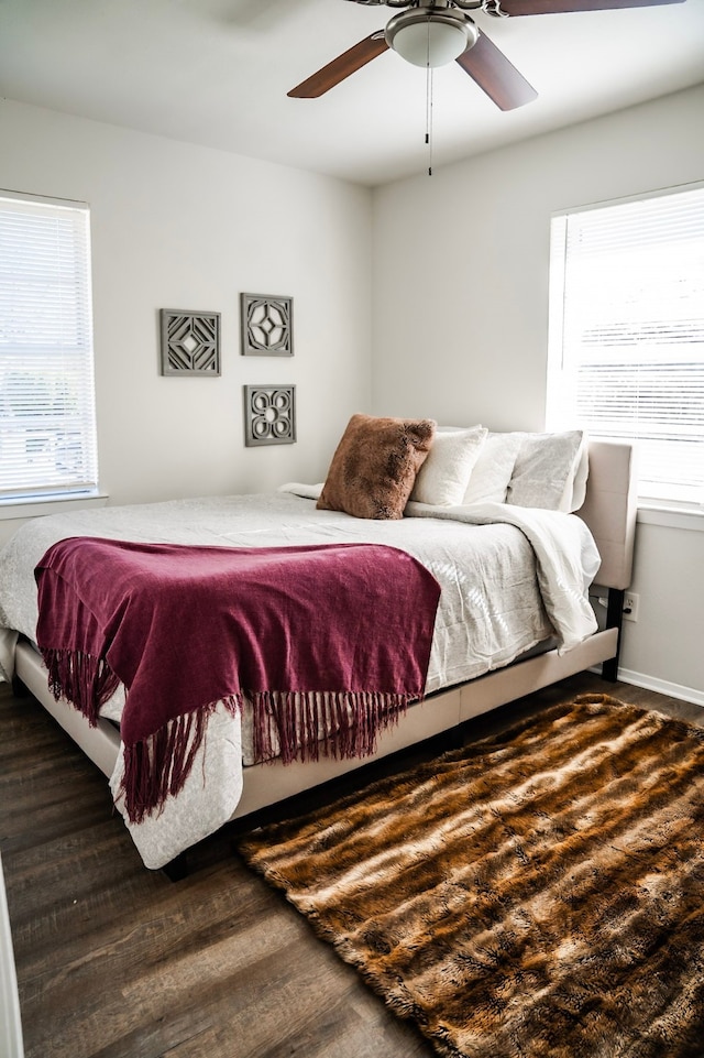 bedroom with multiple windows, dark wood-type flooring, and ceiling fan