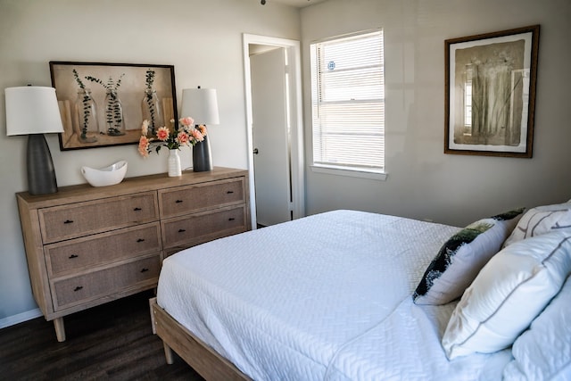 bedroom with dark hardwood / wood-style floors and multiple windows