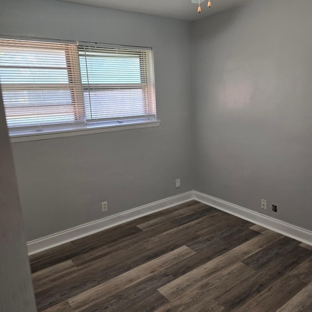 empty room featuring ceiling fan and dark hardwood / wood-style flooring