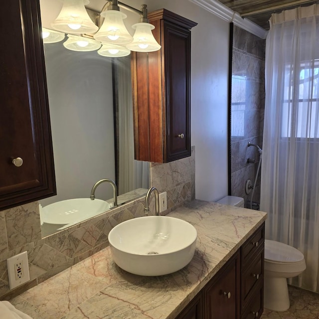 bathroom with vanity, toilet, ornamental molding, and backsplash