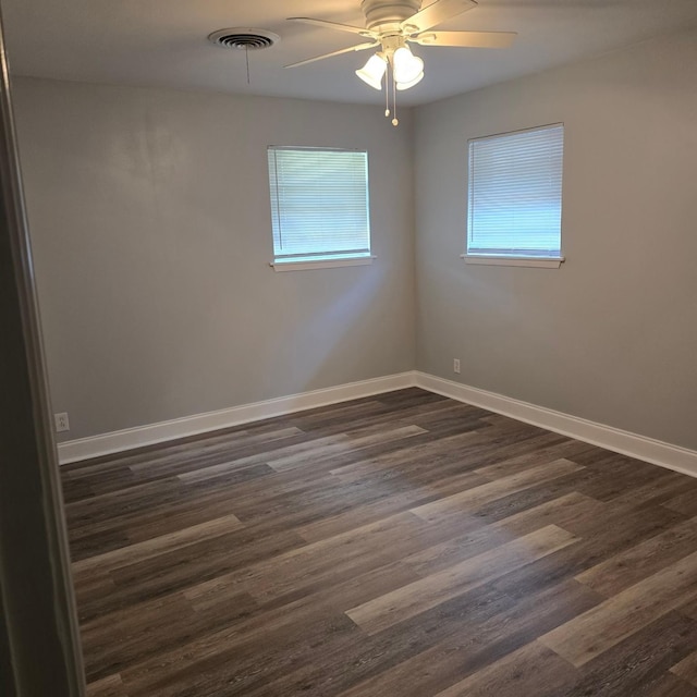 unfurnished room with ceiling fan and dark wood-type flooring