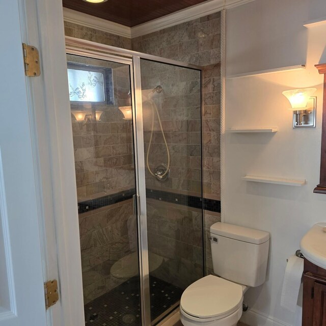 bathroom with vanity, toilet, ornamental molding, and walk in shower