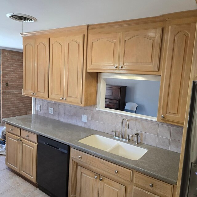 kitchen featuring dishwasher, backsplash, sink, light tile patterned floors, and stainless steel refrigerator