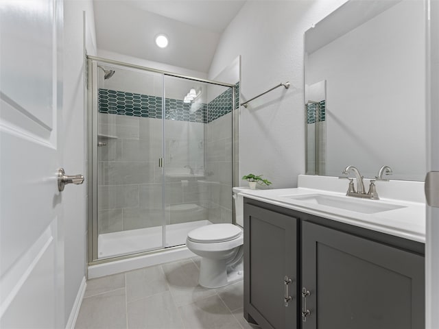 bathroom featuring tile patterned floors, a shower with door, vanity, and toilet