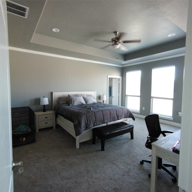 bedroom featuring a raised ceiling, ceiling fan, and carpet flooring