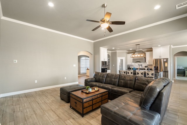 living room featuring ceiling fan and crown molding