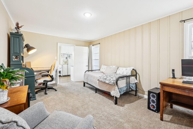 carpeted bedroom featuring crown molding and a crib