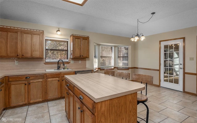 kitchen with pendant lighting, sink, plenty of natural light, and a kitchen island