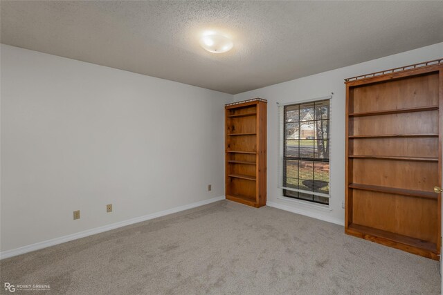 carpeted empty room with a textured ceiling