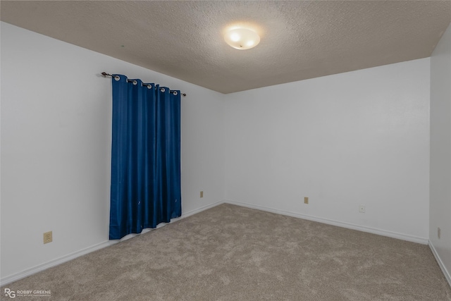 unfurnished room featuring carpet flooring and a textured ceiling