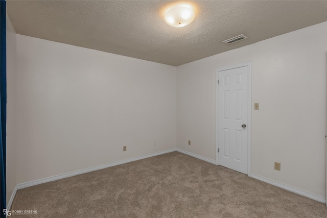 carpeted spare room with a textured ceiling