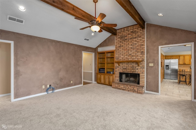 unfurnished living room with a brick fireplace, lofted ceiling with beams, light colored carpet, and ceiling fan