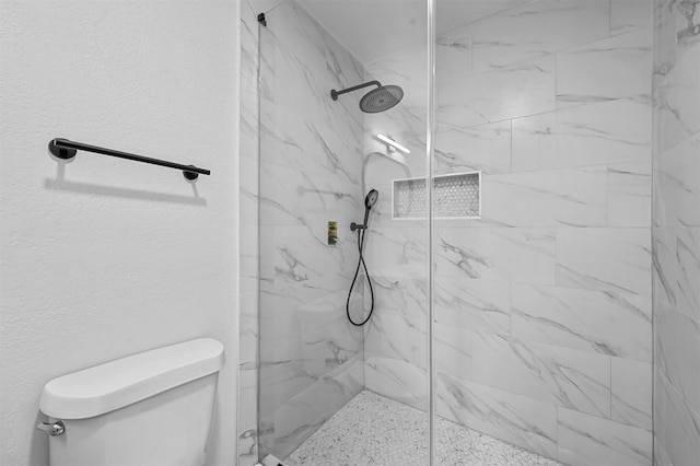 bathroom with tiled shower and toilet