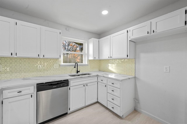 kitchen featuring backsplash, white cabinetry, stainless steel dishwasher, and sink