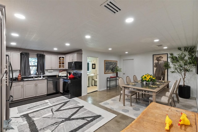 kitchen featuring electric stove, stainless steel dishwasher, white cabinetry, and sink