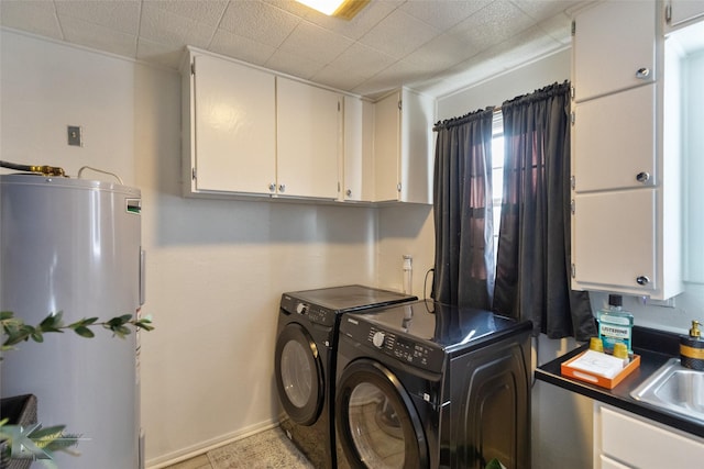 laundry area with washer and dryer, cabinets, electric water heater, and sink