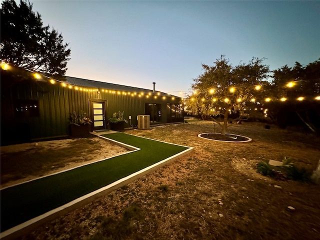 yard at dusk featuring central air condition unit