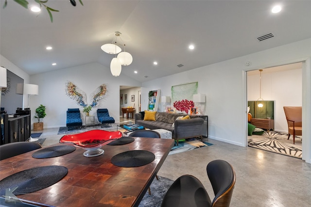 dining room featuring concrete floors and vaulted ceiling