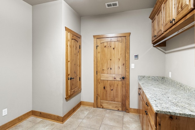 laundry area with light tile patterned flooring