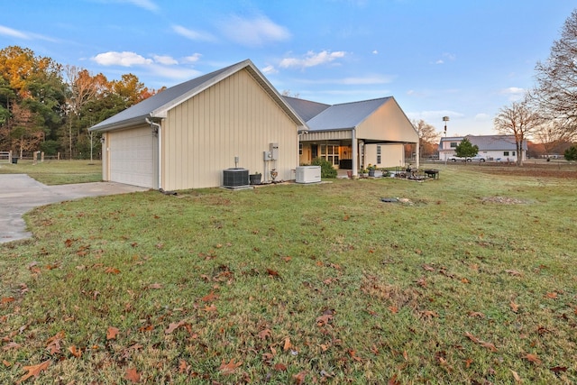 view of property exterior with a yard and central AC