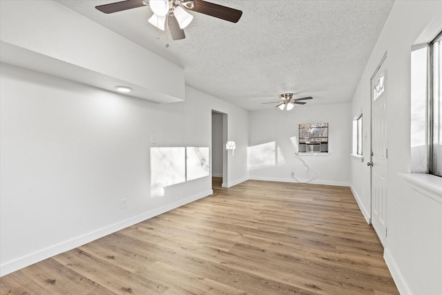 unfurnished living room with ceiling fan, light hardwood / wood-style floors, and a textured ceiling