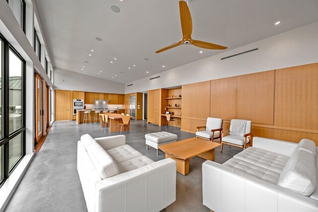 living room with ceiling fan and high vaulted ceiling