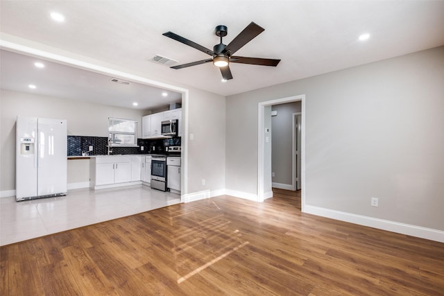 unfurnished living room featuring ceiling fan and light hardwood / wood-style floors