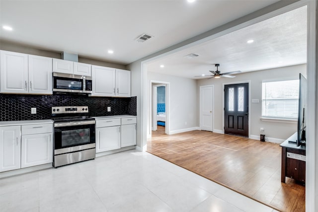 kitchen with decorative backsplash, appliances with stainless steel finishes, ceiling fan, light hardwood / wood-style flooring, and white cabinetry