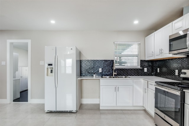 kitchen featuring white cabinets, sink, decorative backsplash, light tile patterned floors, and appliances with stainless steel finishes