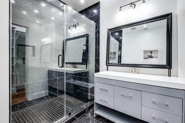 bathroom with ceiling fan, a shower with shower door, and vanity