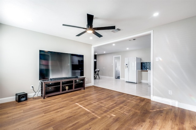 living room featuring light wood-type flooring and ceiling fan