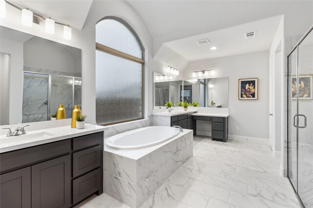 bathroom featuring vanity, separate shower and tub, and vaulted ceiling