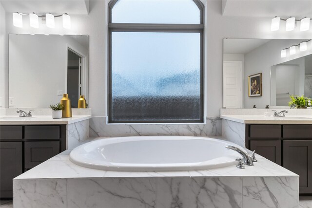 bathroom featuring vanity and tiled tub