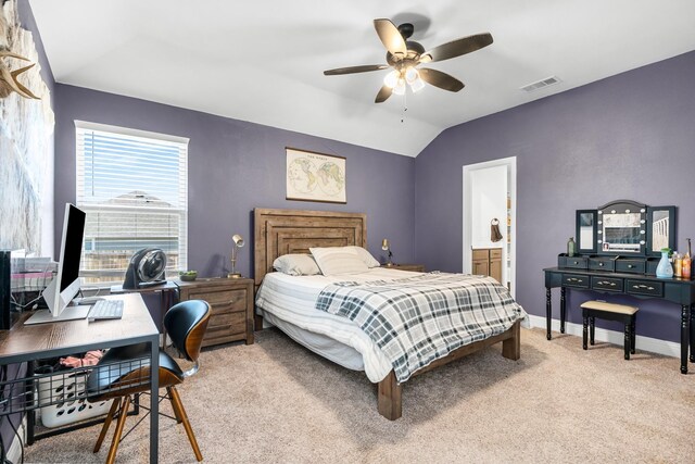 bedroom with ceiling fan, light colored carpet, ensuite bath, and vaulted ceiling