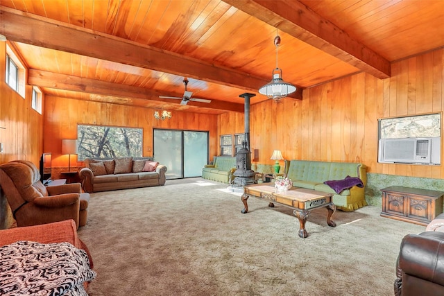 living room with beamed ceiling, a wood stove, cooling unit, and carpet flooring