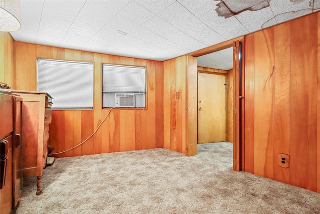 spare room with carpet floors, cooling unit, and wooden walls