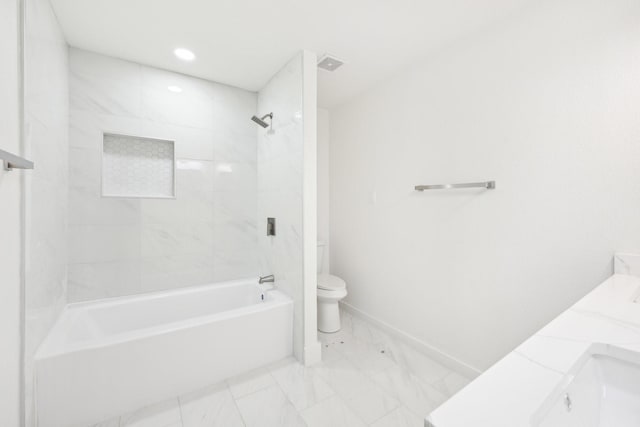 full bathroom featuring tiled shower / bath combo, toilet, and vanity