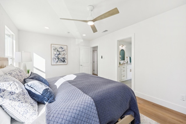 bedroom featuring ensuite bathroom, light hardwood / wood-style flooring, and ceiling fan